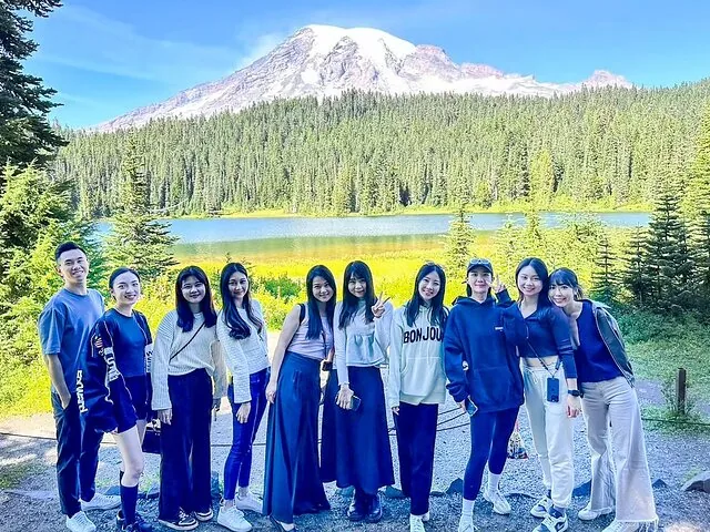 Gruppe posiert vor einem See und dem Mount Rainier