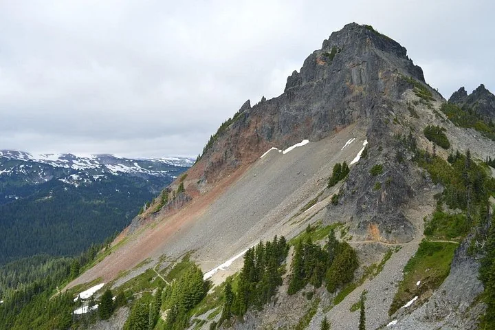 A towering rocky peak with a scree slope in Mount Rainier National Park.