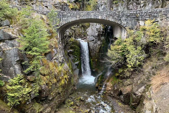 Un puente de arco de piedra sobre Christine Falls, que se precipita en un desfiladero rocoso.